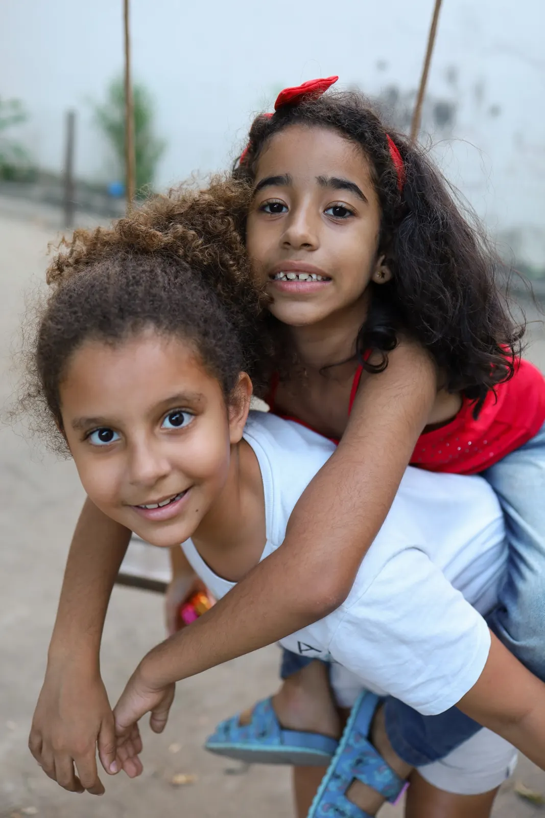 Duas amigas abraçadas sorriem para a câmera
