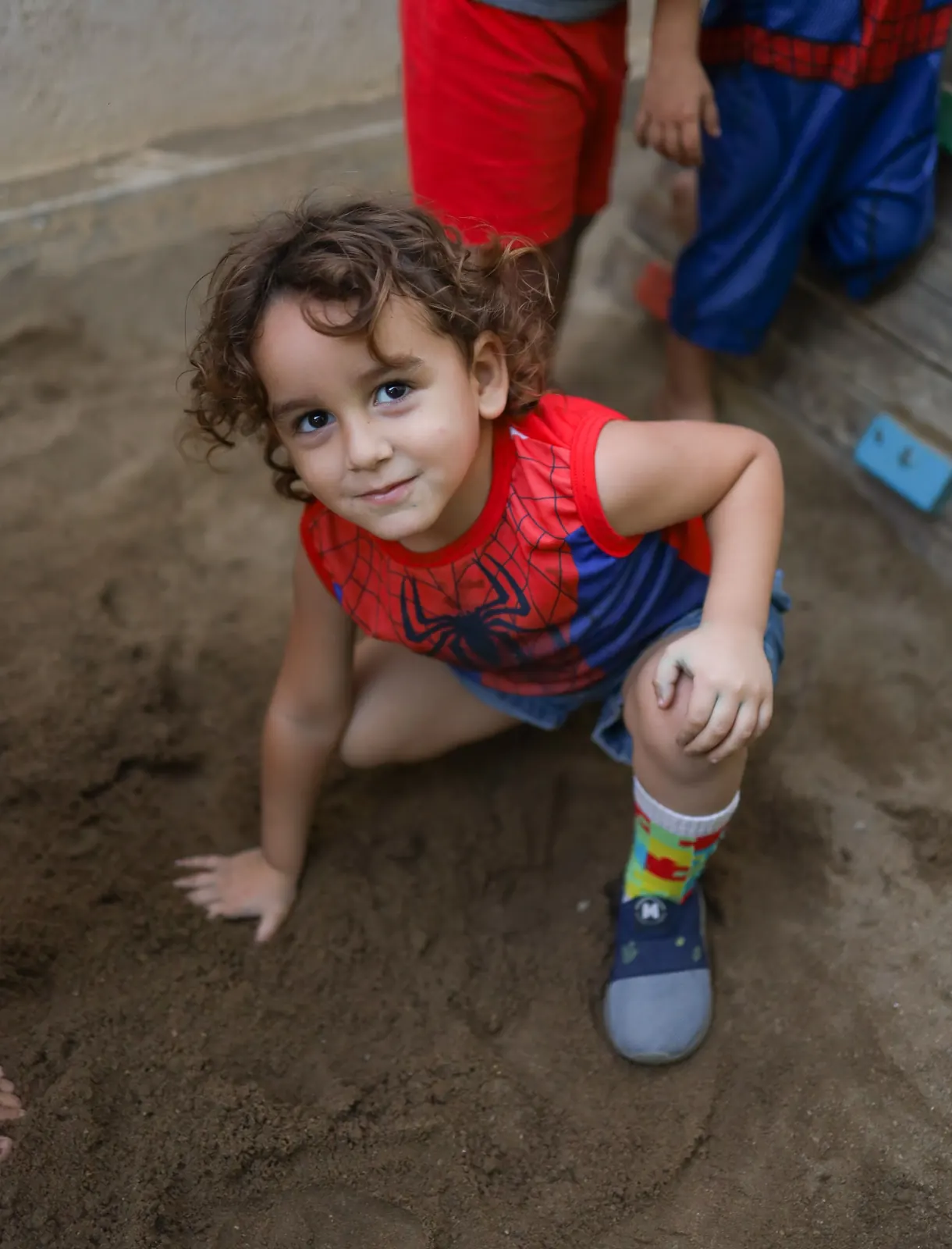 Criança pequena brinca na areia