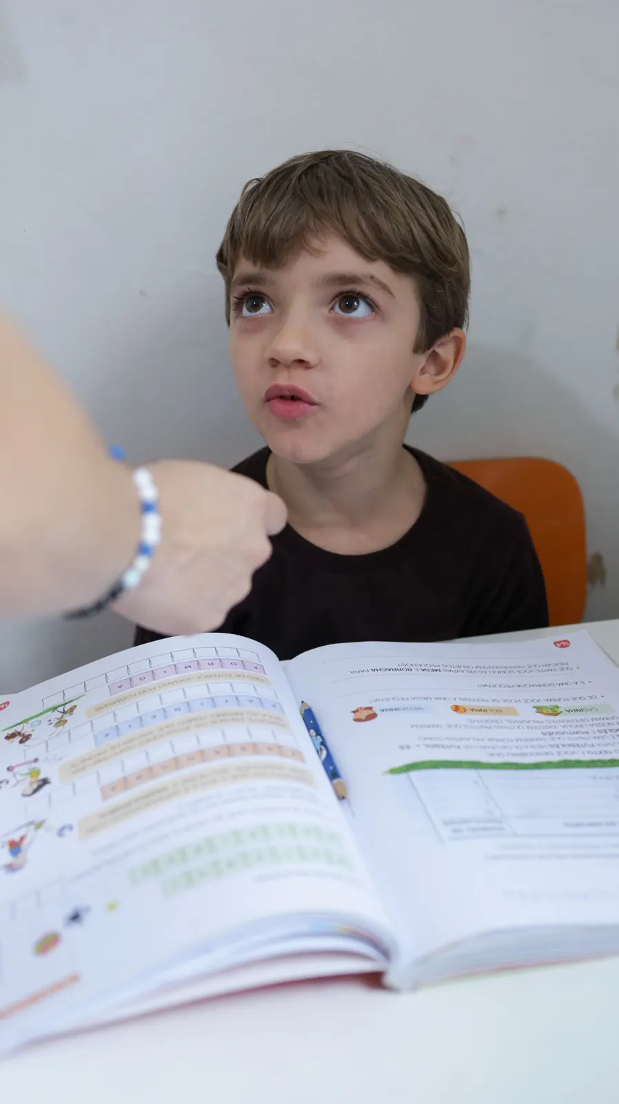 Menino lê um livro em sala