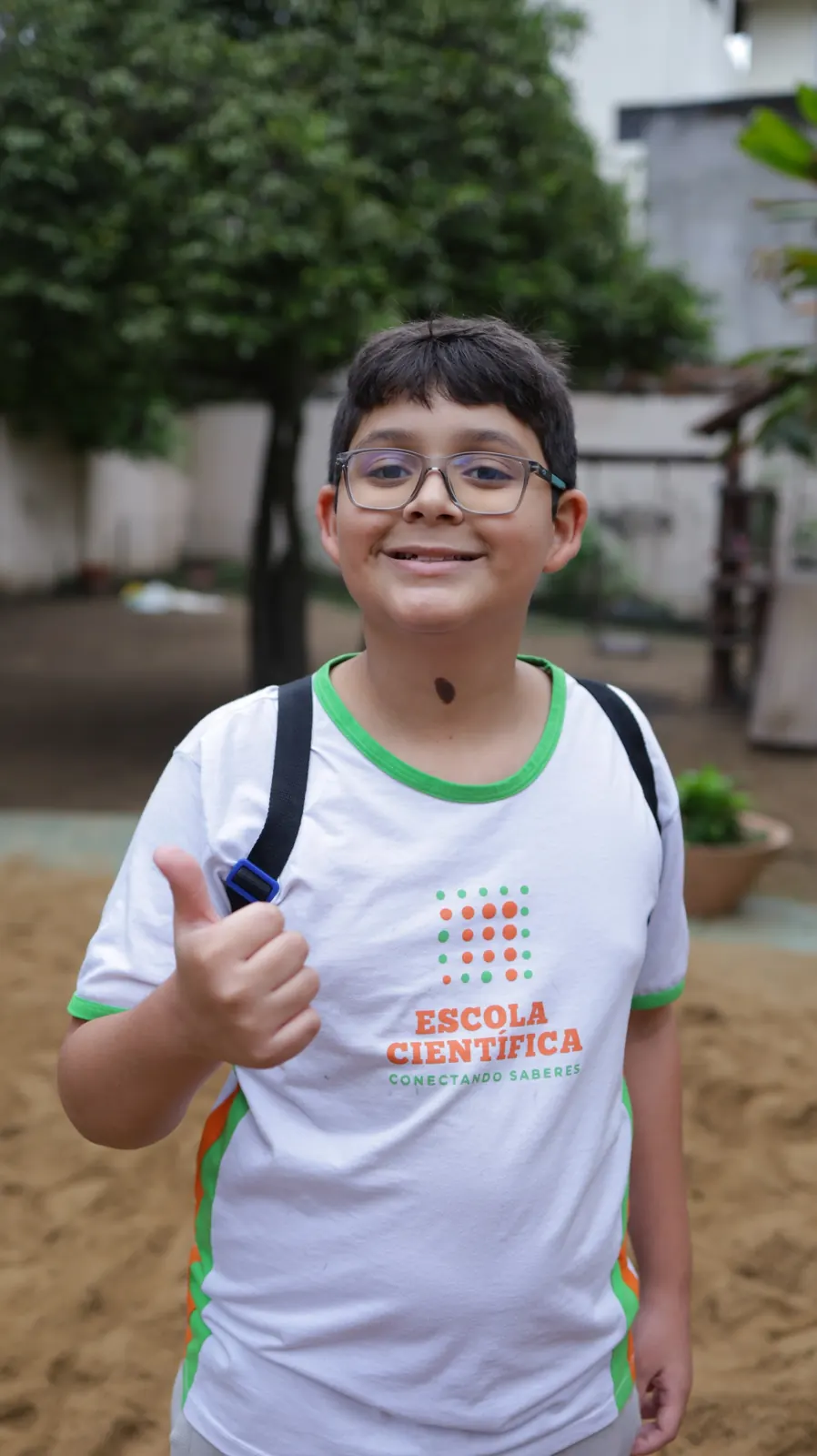 Estudante de uniforme faz sinal de positivo